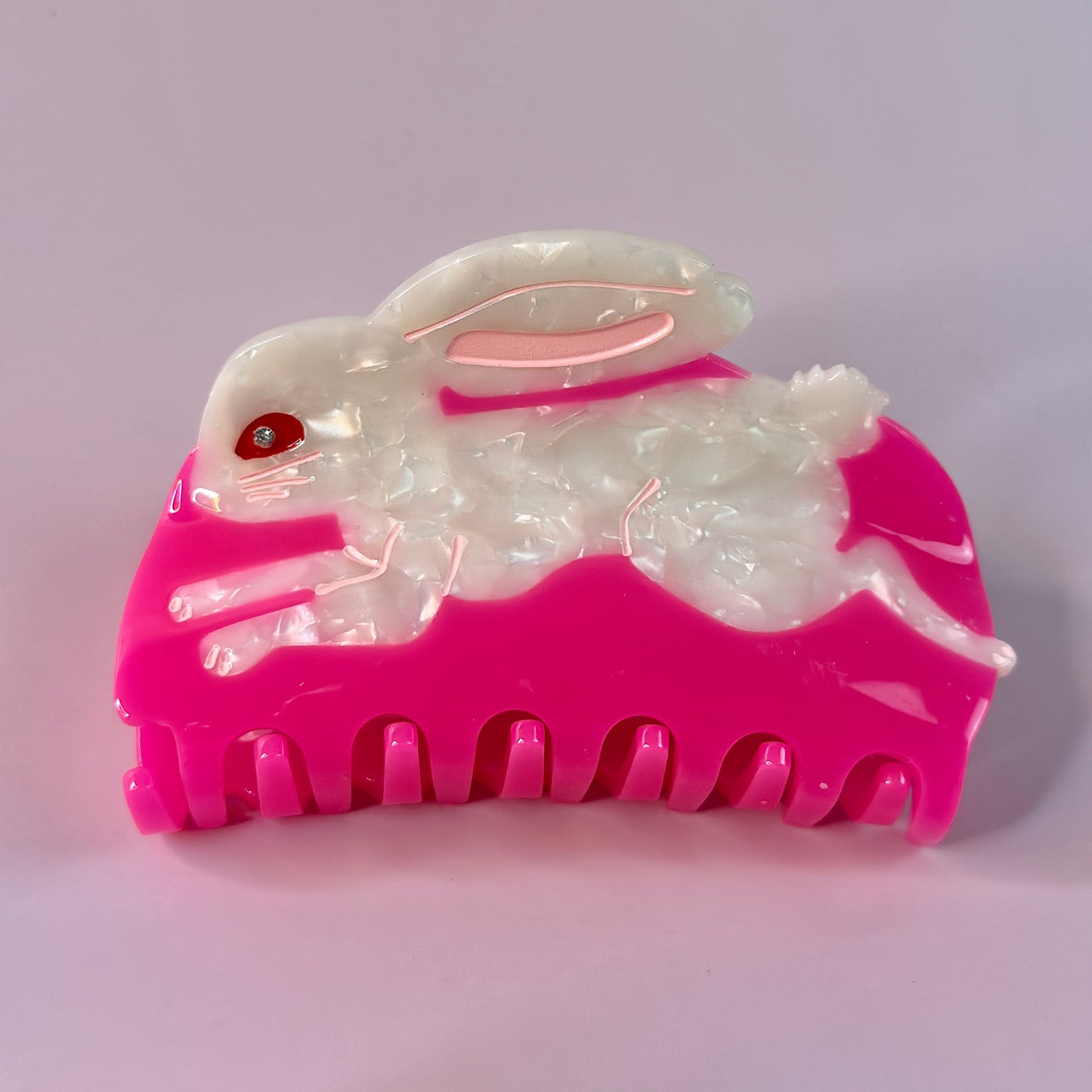 White bunny on a pink hair claw.