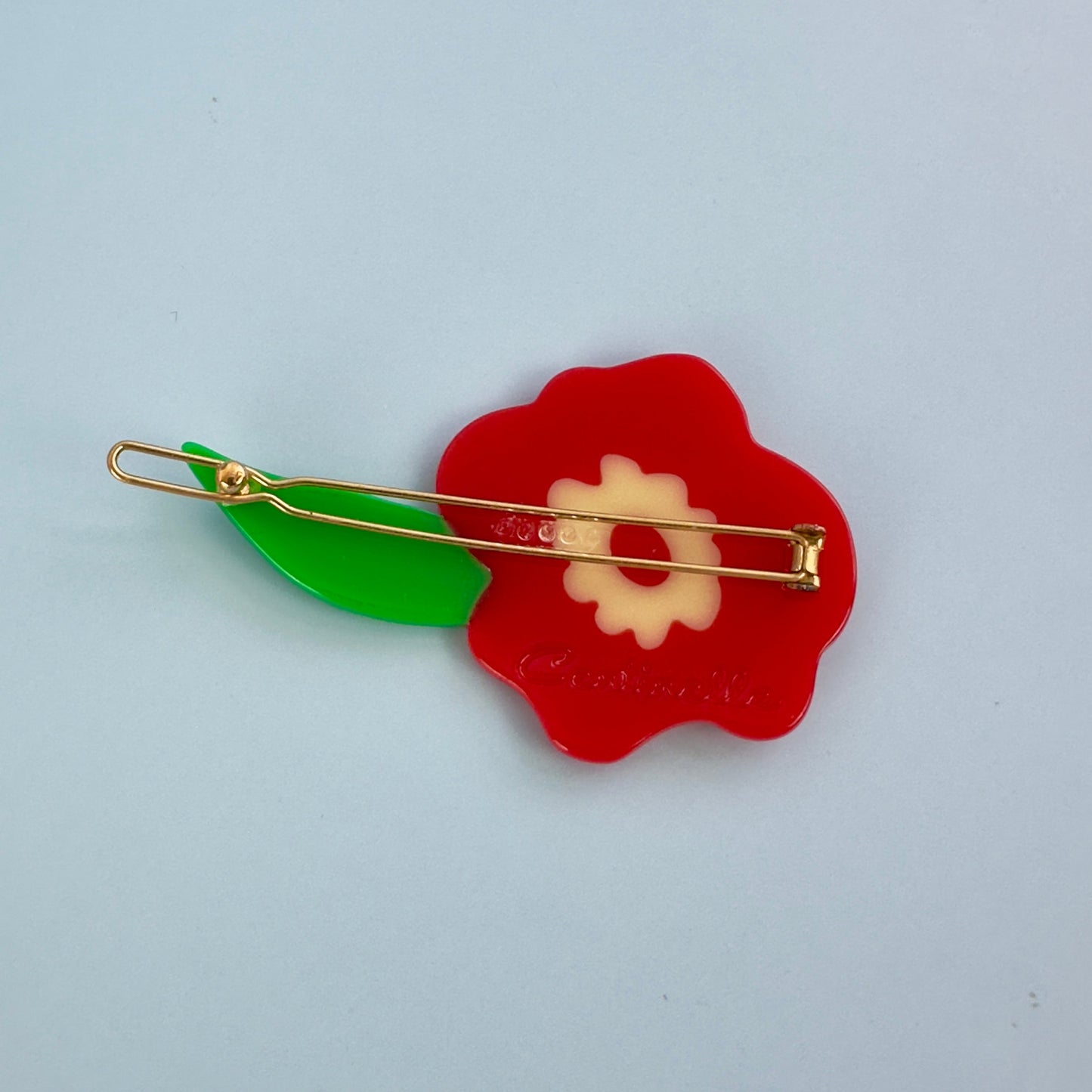 Red flower hair clip from cat garden gnome collection from Centinelle, with green leaf.