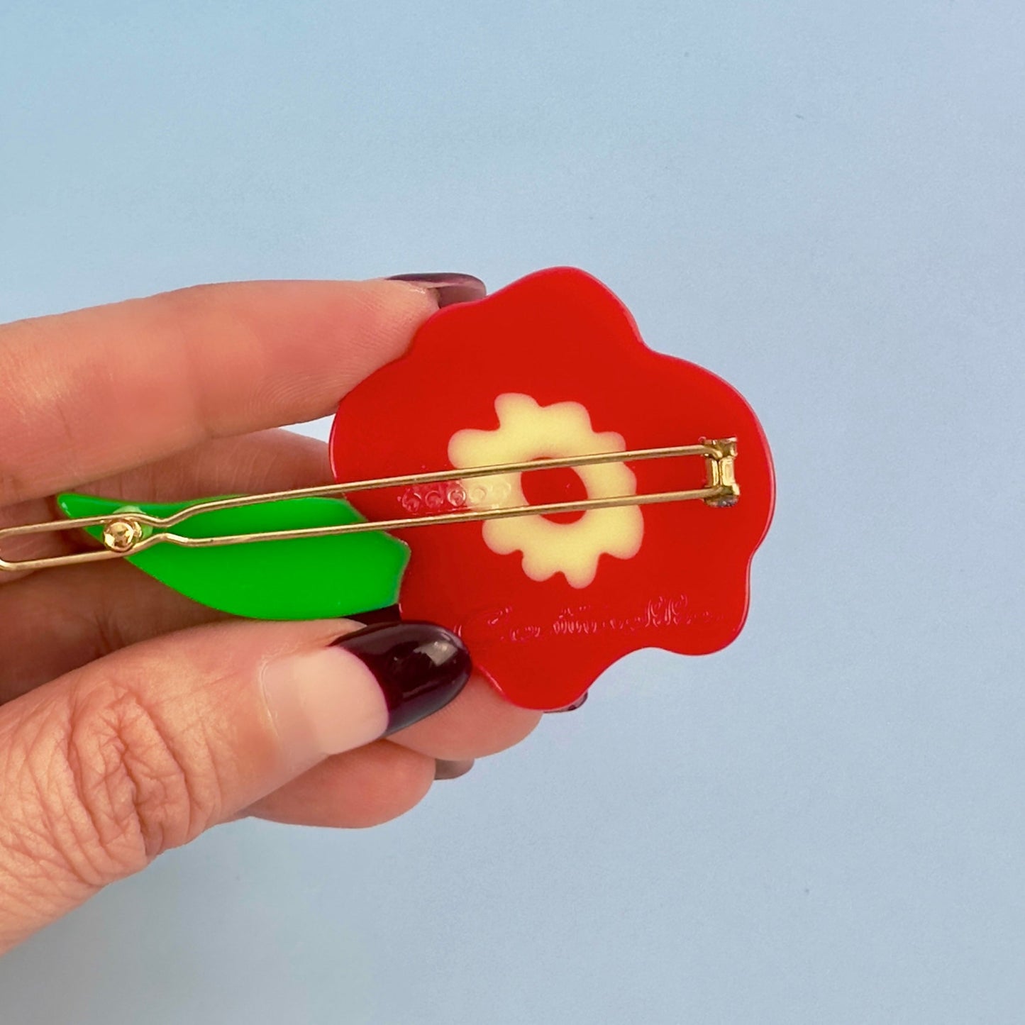 Red flower hair clip from cat garden gnome collection from Centinelle, with green leaf.