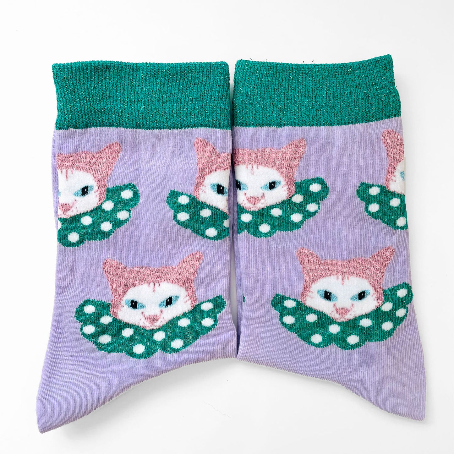 Purple and green socks with white cat clowns.