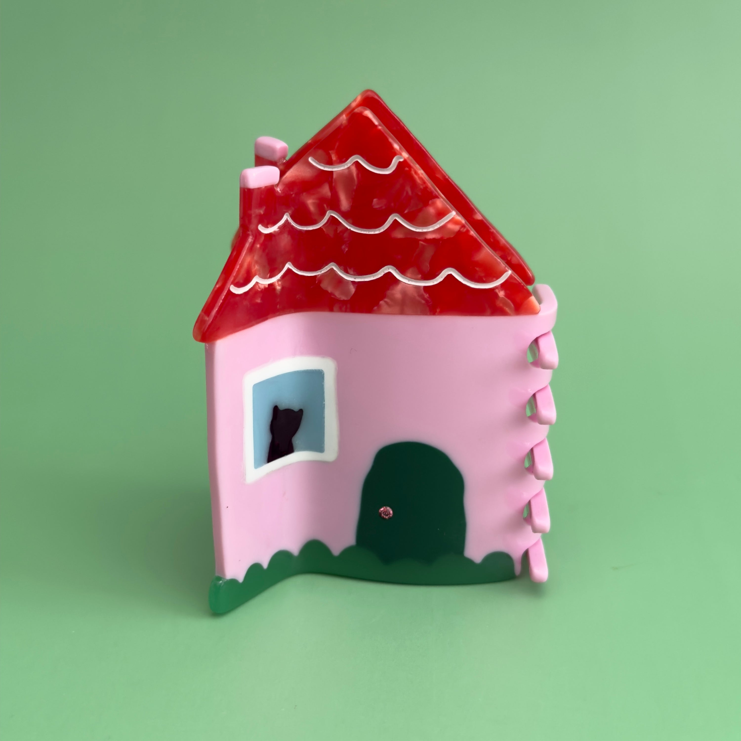 This charmin house hair claw, comes with an extra purr-k: a resident feline who will charmingly oversee the neighborhood from their sun-drenched window perch.

This practical yet cozy house hair claw, will hold strong as it's pink foundation. 

Who says you can afford a house! hehe, now you can! 