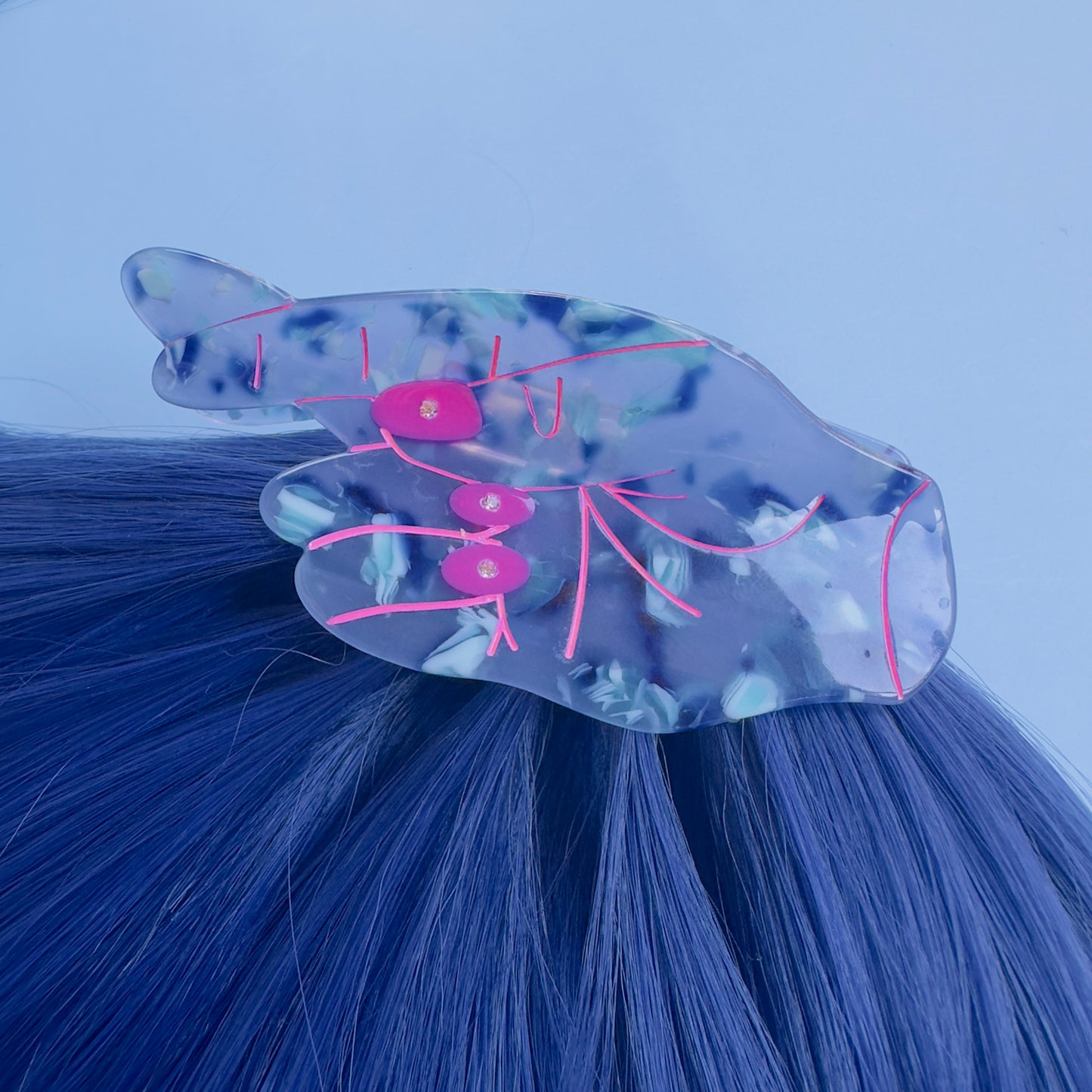 Blue crossing fingers hair claw with pink outlines.