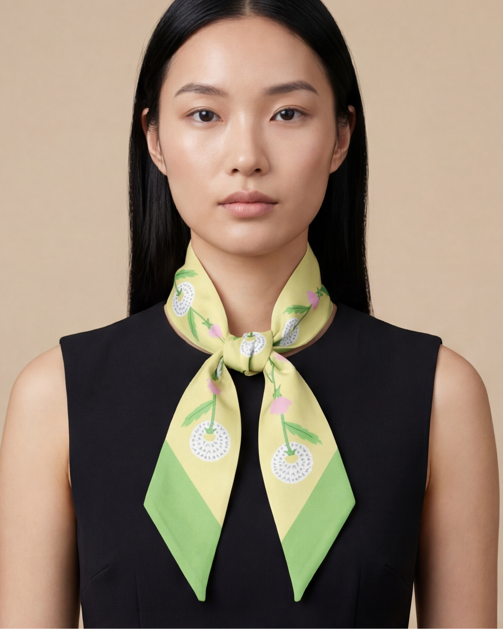Woman wearing a green and yellow dandelion patterned scarf on a beige background