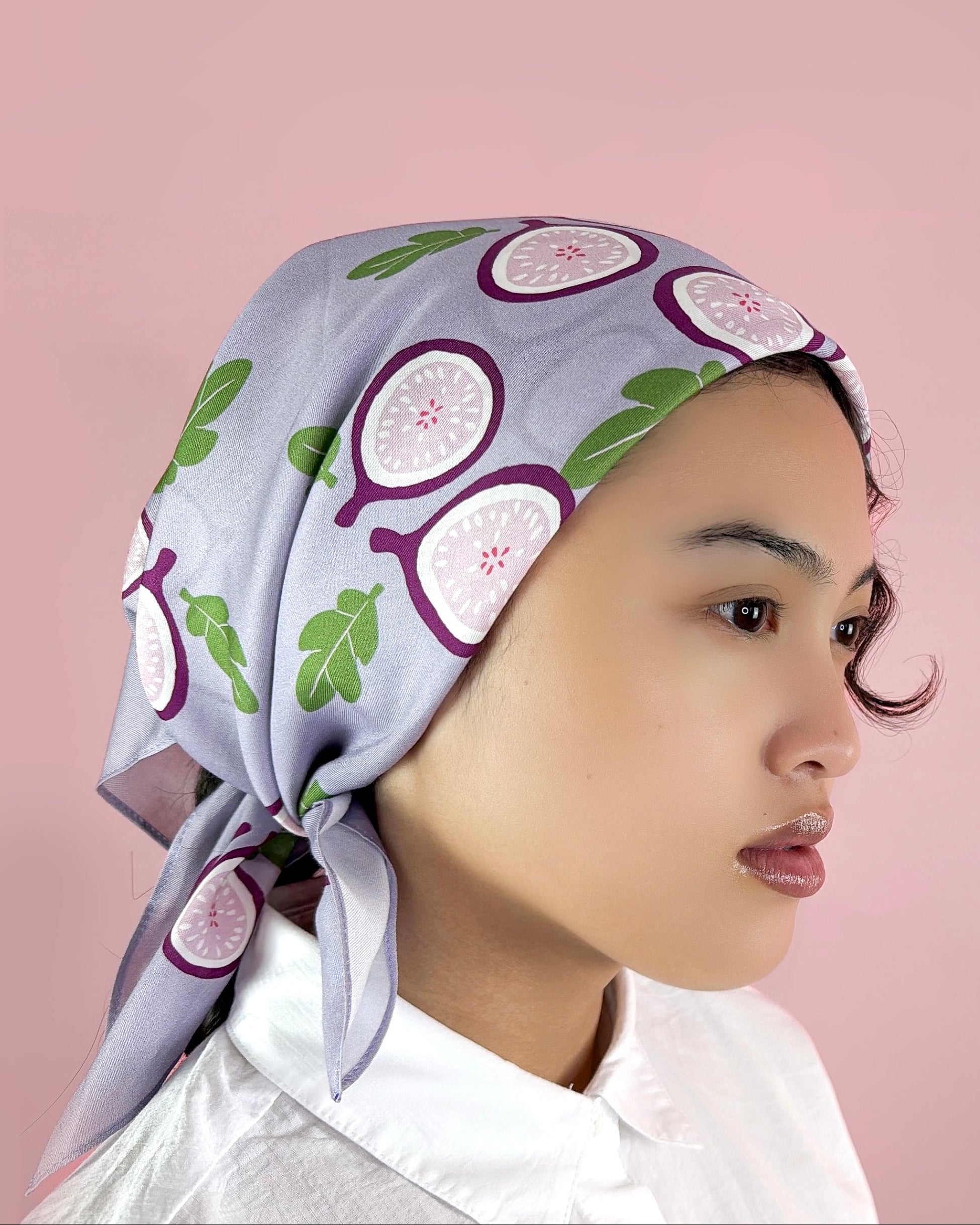 Woman wearing a headscarf with fig pattern on a pink background