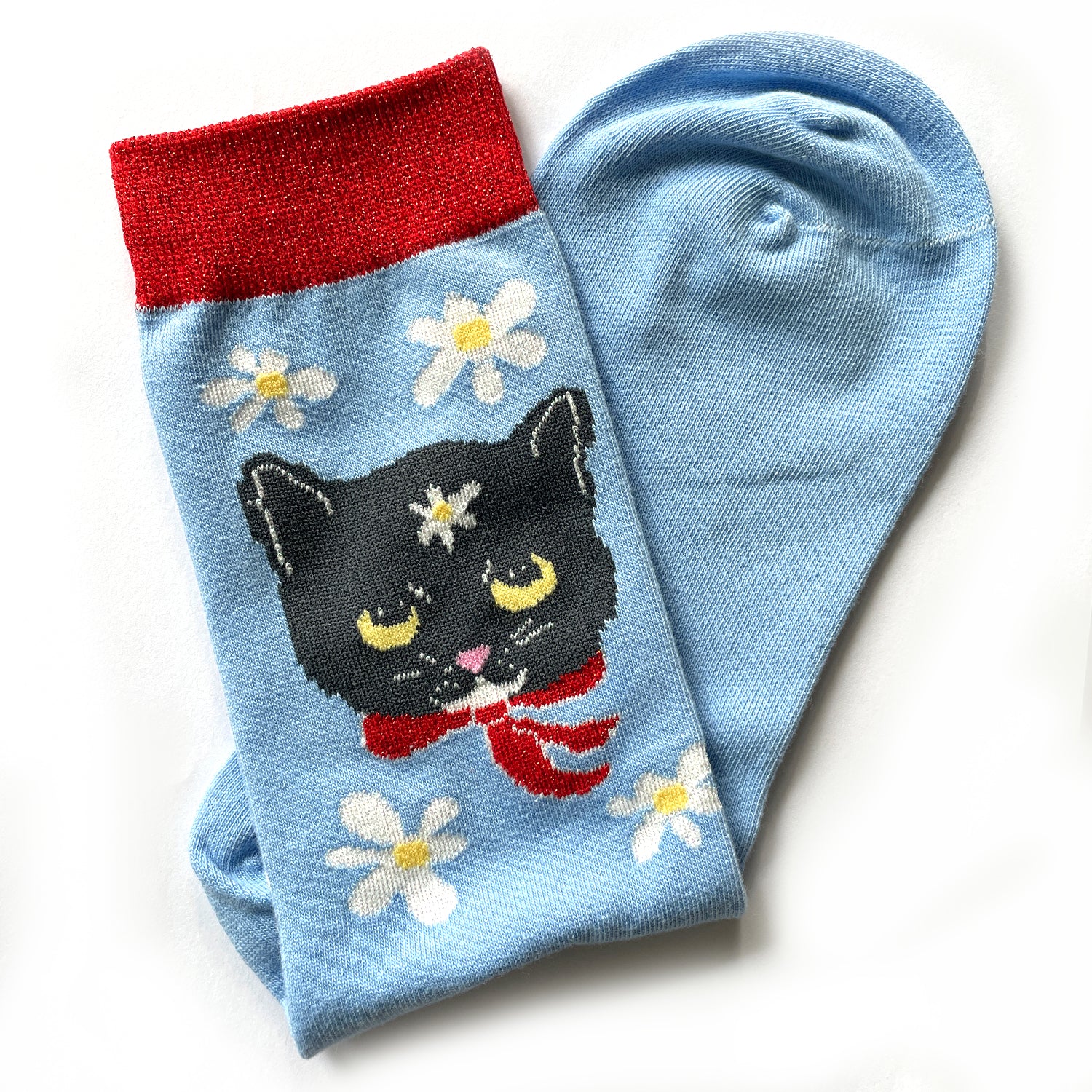 Red and blue sock with white daisies and black cat.