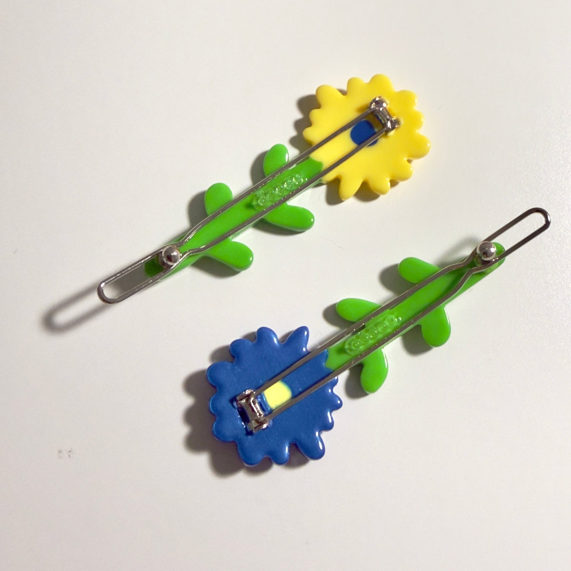 Two hair clips with flower designs on a white background